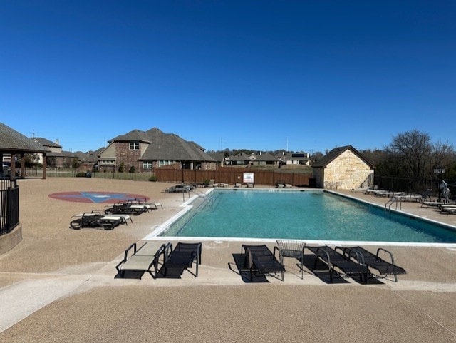 community pool with fence and a patio