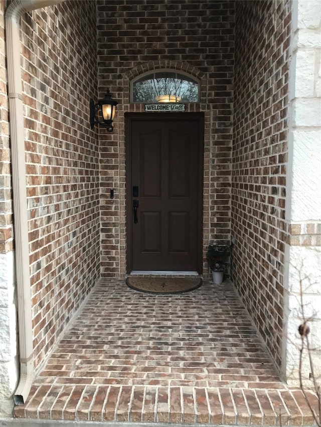 entrance to property featuring brick siding