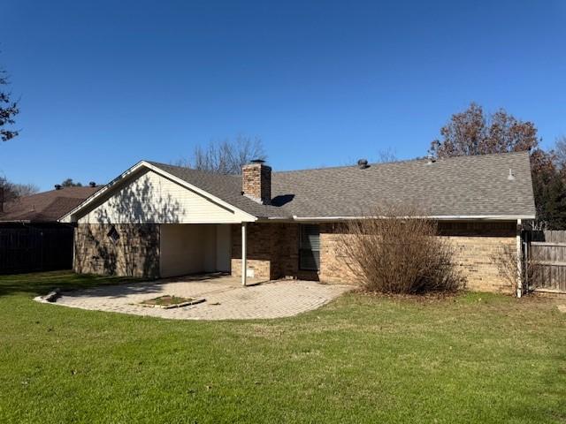 rear view of property with a lawn and a patio area