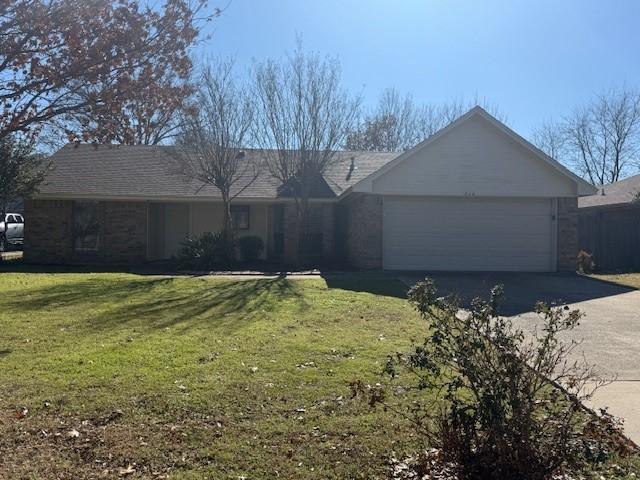 ranch-style house with a garage and a front yard