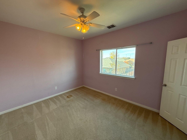 carpeted spare room featuring ceiling fan