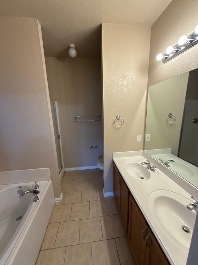 bathroom featuring vanity, a bath, tile patterned floors, and toilet