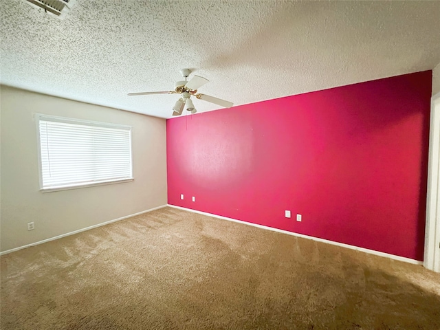 carpeted empty room featuring ceiling fan and a textured ceiling