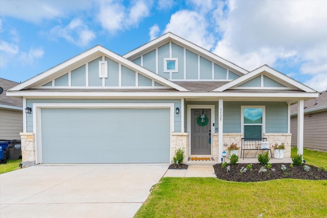 view of front of home with a porch, a garage, and a front yard