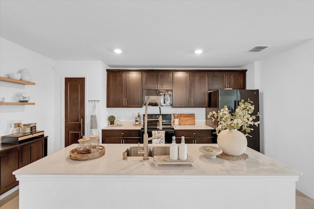 kitchen with freestanding refrigerator, light countertops, dark brown cabinetry, and electric range oven