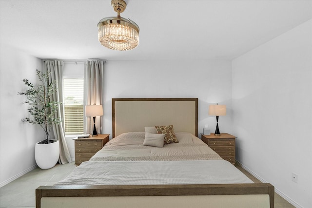 bedroom with an inviting chandelier and baseboards