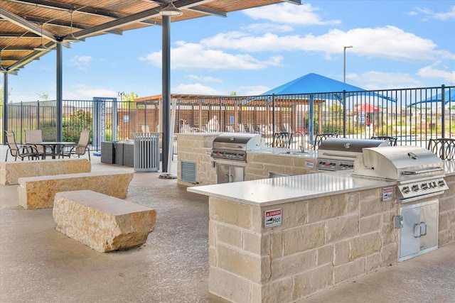 view of patio featuring exterior kitchen, fence, and area for grilling