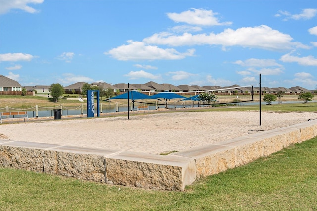 view of community with a water view, a yard, and volleyball court