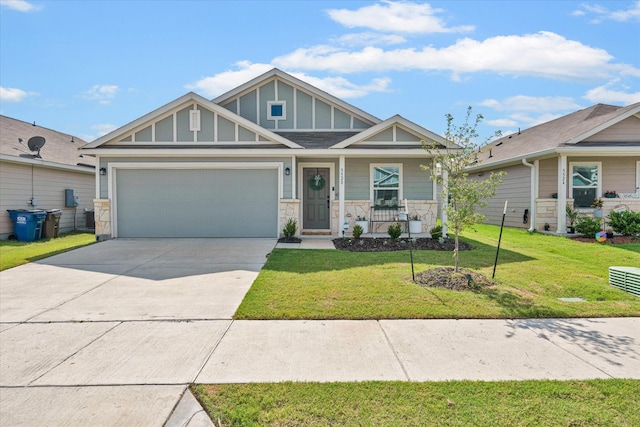 craftsman-style home with covered porch, stone siding, concrete driveway, board and batten siding, and a front yard