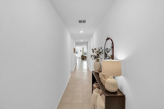 corridor featuring light tile patterned floors, baseboards, visible vents, and recessed lighting