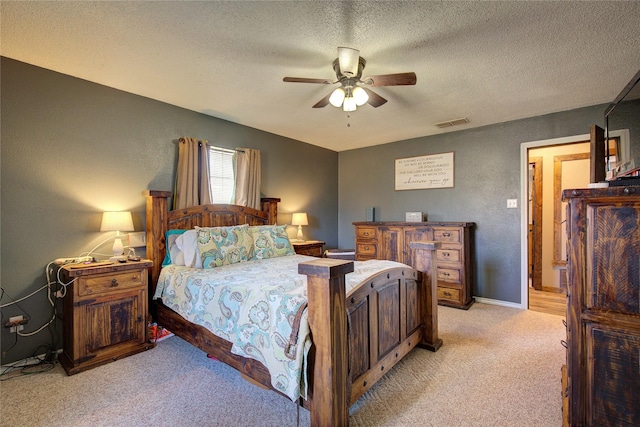 carpeted bedroom featuring ceiling fan and a textured ceiling