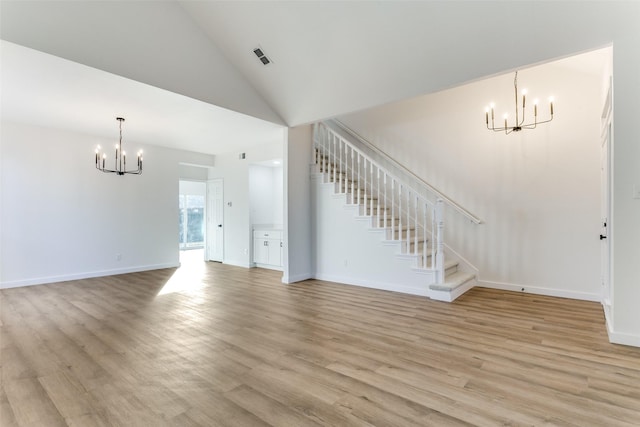 unfurnished living room with an inviting chandelier, light hardwood / wood-style flooring, and high vaulted ceiling