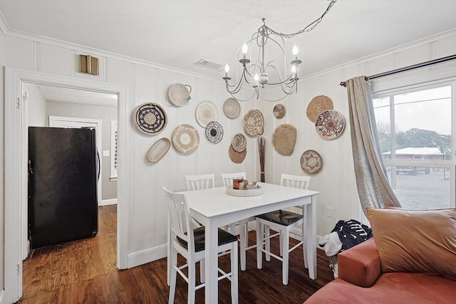 dining room featuring crown molding, dark wood-type flooring, and a notable chandelier