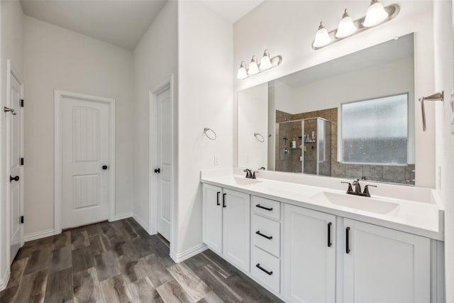 bathroom with an enclosed shower, vanity, and wood-type flooring