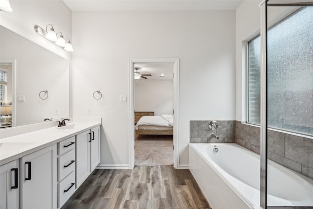 bathroom featuring ceiling fan, vanity, a bath, and hardwood / wood-style floors