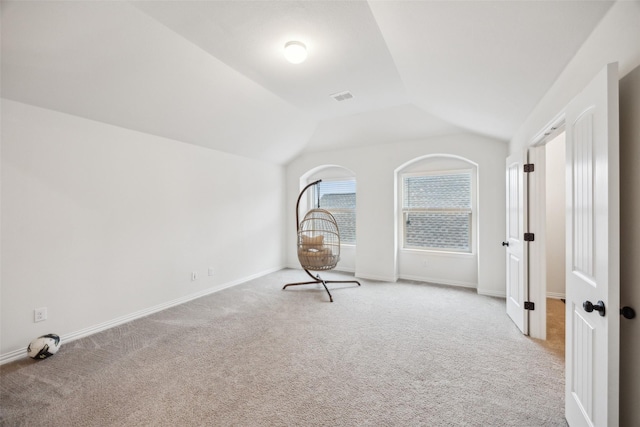 unfurnished room with lofted ceiling and light carpet