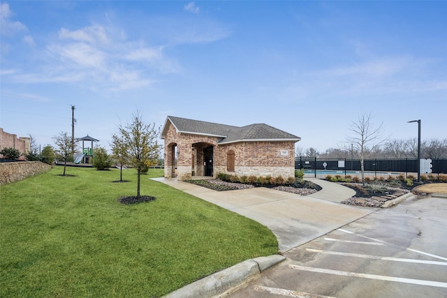 view of front of home featuring a front yard and a playground