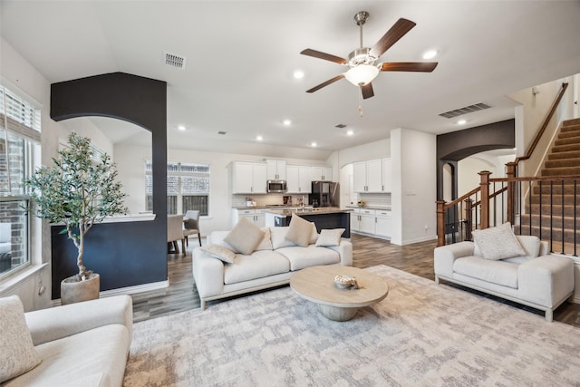 living room featuring ceiling fan, lofted ceiling, and hardwood / wood-style floors