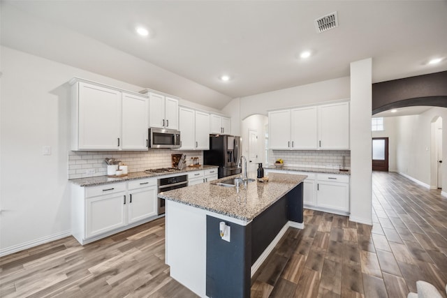 kitchen featuring white cabinetry, appliances with stainless steel finishes, and a center island with sink