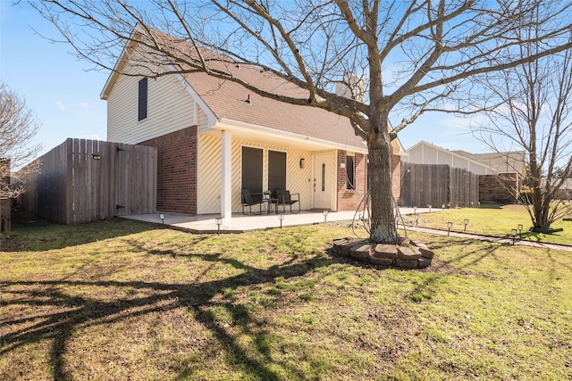 back of property with a yard and a patio area