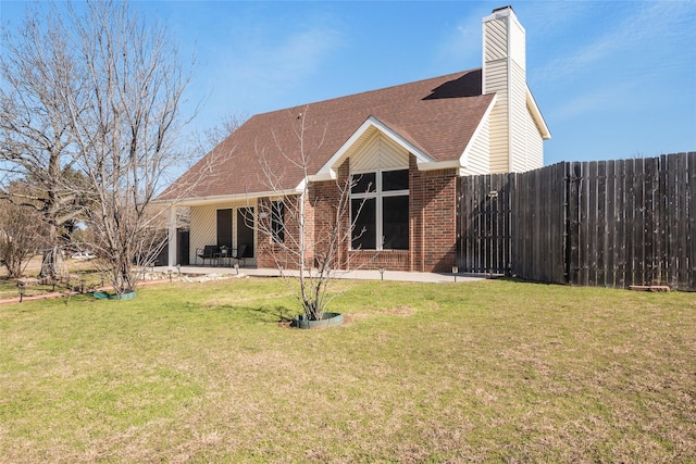 back of house with a yard and a patio