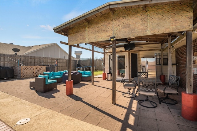 view of patio with a trampoline, outdoor lounge area, and ceiling fan