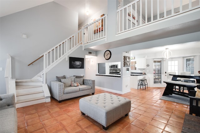 living room with a towering ceiling and light tile patterned floors