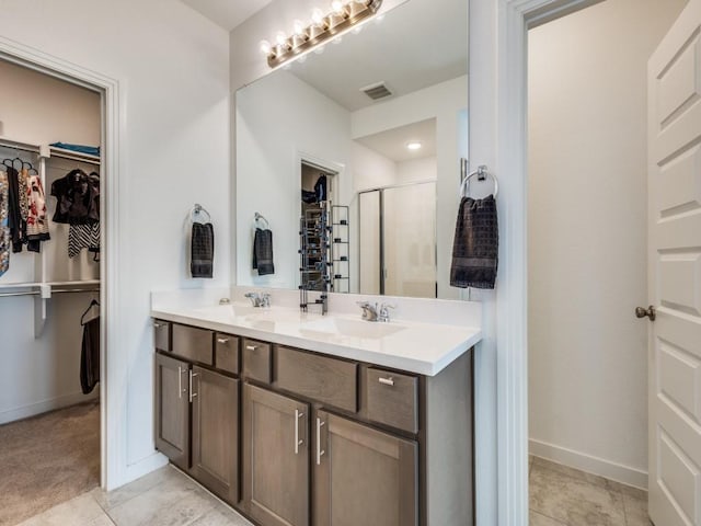 bathroom featuring vanity, an enclosed shower, and tile patterned floors