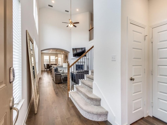 entrance foyer featuring dark hardwood / wood-style flooring, a towering ceiling, and ceiling fan