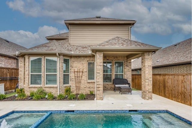 back of property featuring a fenced in pool and a patio