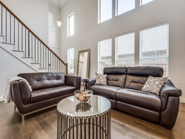 living room with a towering ceiling and hardwood / wood-style floors