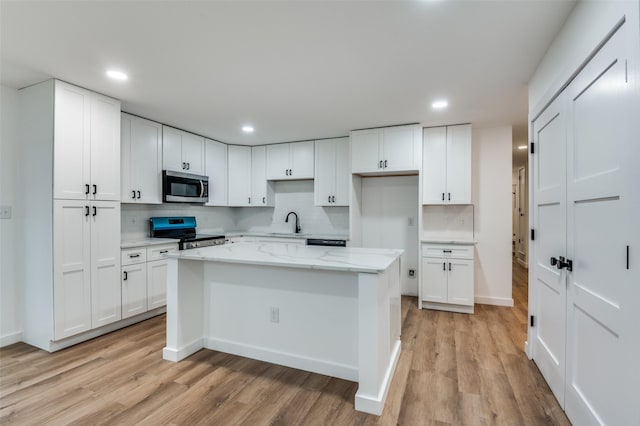 kitchen featuring white cabinetry, appliances with stainless steel finishes, and light stone countertops