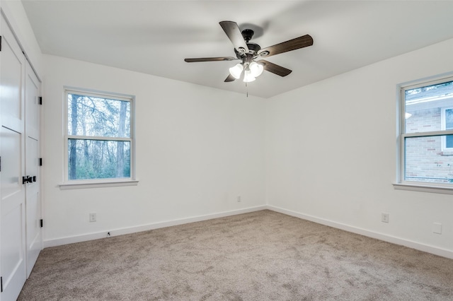 unfurnished room with ceiling fan and light carpet