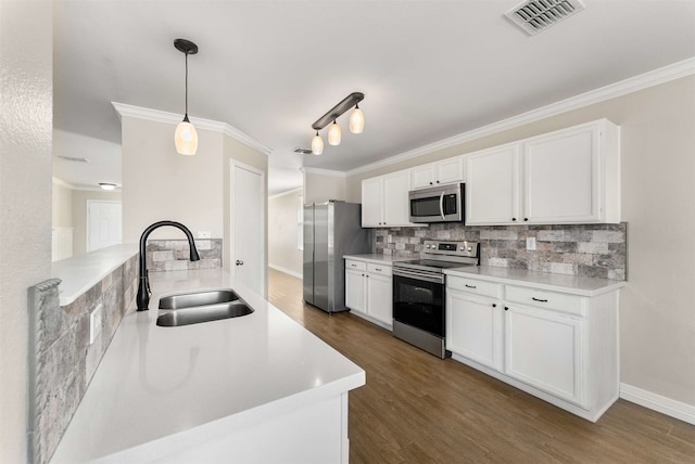 kitchen with sink, white cabinetry, decorative light fixtures, appliances with stainless steel finishes, and backsplash