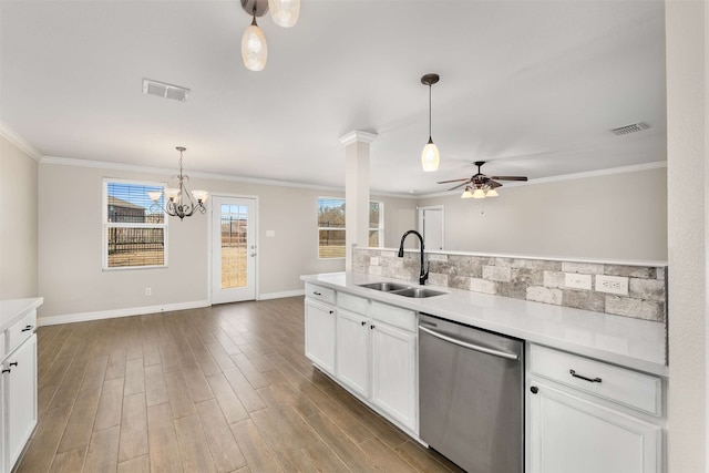 kitchen featuring sink, white cabinetry, ornamental molding, decorative light fixtures, and stainless steel dishwasher