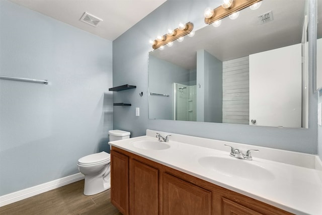 bathroom featuring vanity, wood-type flooring, a shower, and toilet