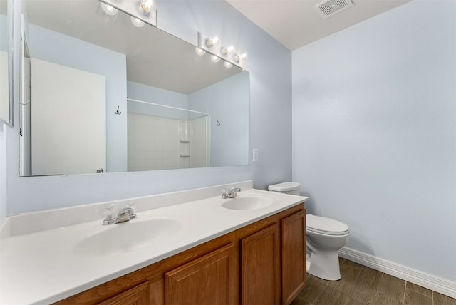 bathroom with walk in shower, vanity, and toilet