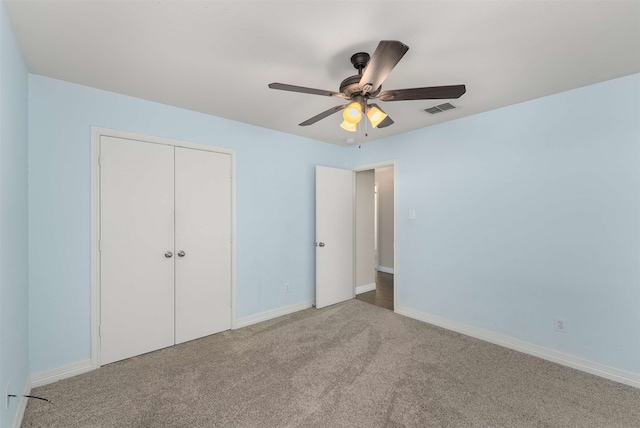 unfurnished bedroom featuring light colored carpet, a closet, and ceiling fan