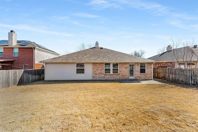 back of property featuring a lawn and a patio