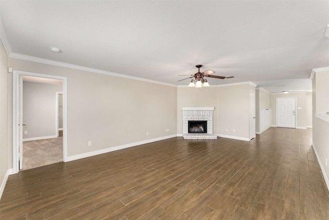 unfurnished living room featuring ornamental molding, dark wood-type flooring, ceiling fan, and a fireplace