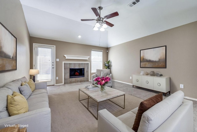 living area with baseboards, visible vents, vaulted ceiling, and light colored carpet