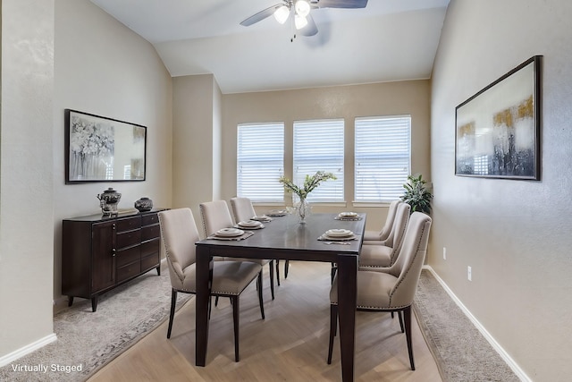 dining space featuring lofted ceiling, ceiling fan, light wood finished floors, and baseboards