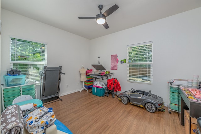 game room with ceiling fan and light wood-type flooring