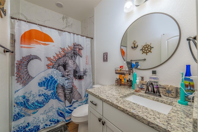 bathroom featuring vanity, curtained shower, and toilet