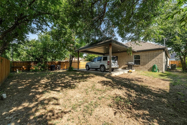 rear view of property featuring central AC and a carport