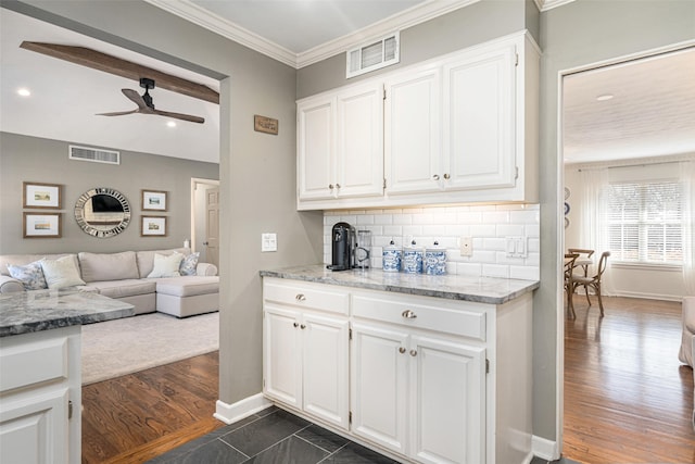 kitchen featuring ornamental molding, dark hardwood / wood-style flooring, ceiling fan, decorative backsplash, and white cabinets