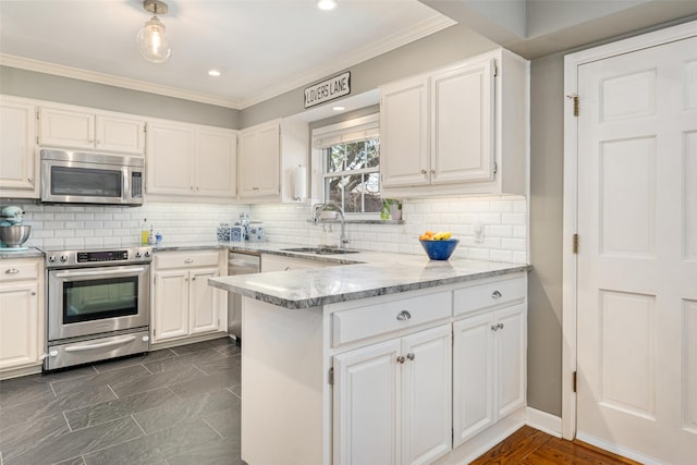 kitchen featuring sink, light stone counters, appliances with stainless steel finishes, kitchen peninsula, and white cabinets