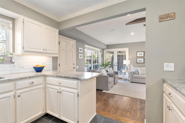 kitchen with decorative backsplash, light stone countertops, french doors, and white cabinets