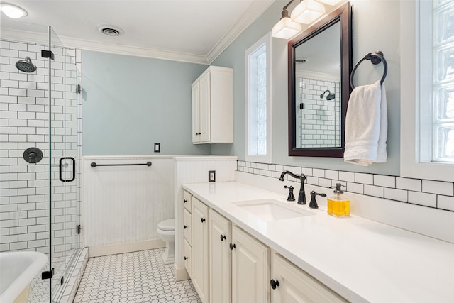 bathroom with ornamental molding, toilet, vanity, and a wealth of natural light