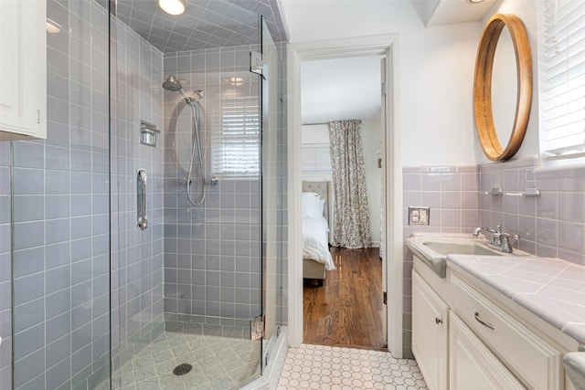 bathroom with vanity, a healthy amount of sunlight, tile walls, and tile patterned floors